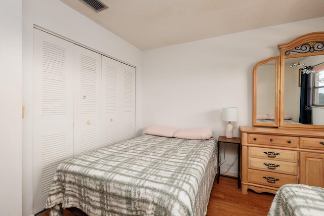 bedroom featuring a textured ceiling, a closet, and wood-type flooring