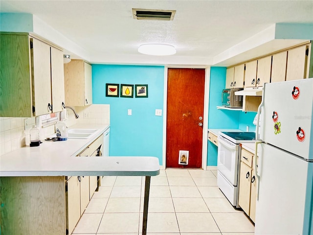 kitchen with light tile patterned flooring, sink, kitchen peninsula, a kitchen bar, and white appliances