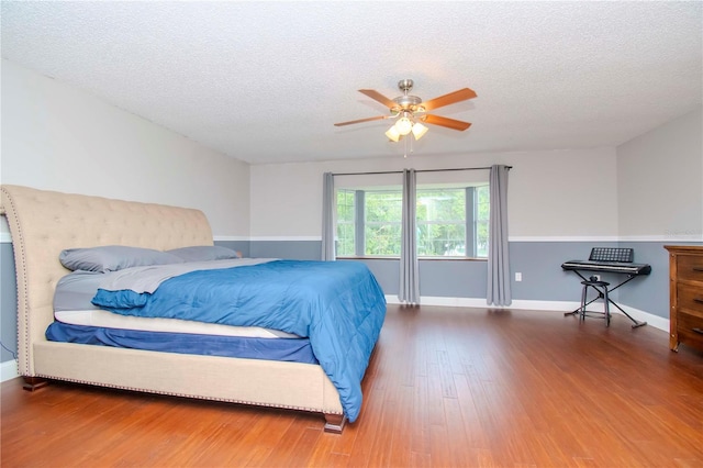 bedroom featuring a textured ceiling, ceiling fan, and wood-type flooring