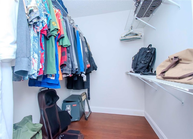 walk in closet with dark hardwood / wood-style flooring