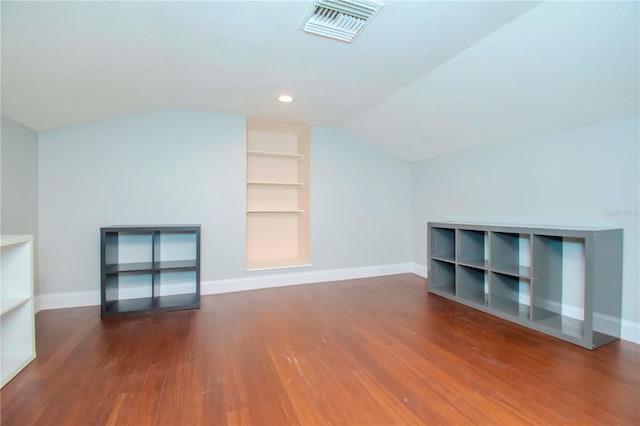 unfurnished living room with vaulted ceiling and dark hardwood / wood-style flooring