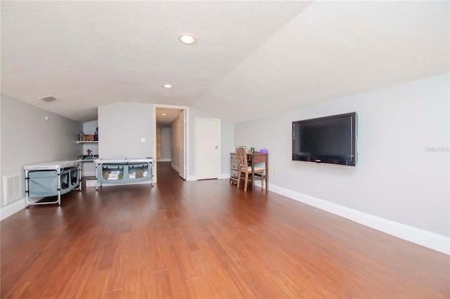 unfurnished living room featuring lofted ceiling, dark hardwood / wood-style flooring, and a textured ceiling