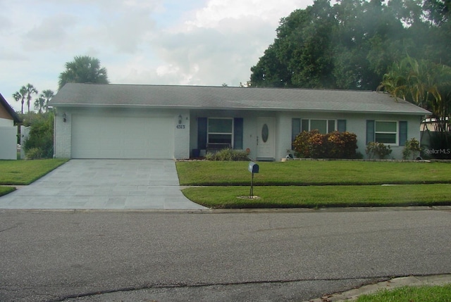 ranch-style home with a front lawn, brick siding, driveway, and an attached garage