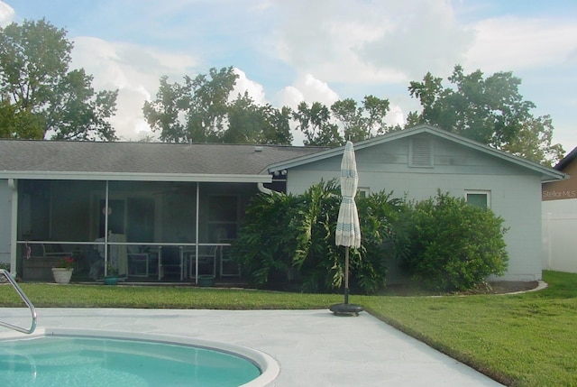 rear view of property with a sunroom and a yard