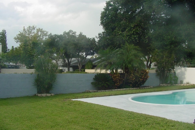 view of swimming pool featuring a lawn