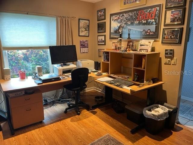 home office with light hardwood / wood-style flooring