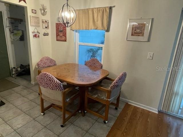 dining area featuring light tile patterned floors and a notable chandelier