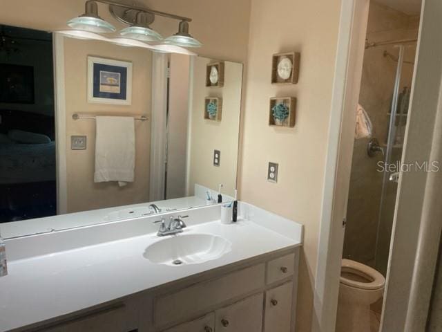 bathroom featuring vanity, toilet, and a shower with door