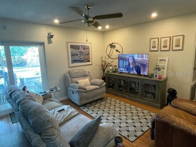 living room with hardwood / wood-style floors and ceiling fan