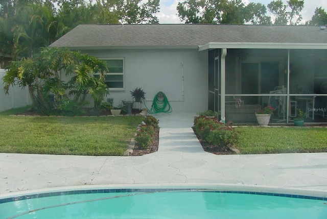 view of pool featuring a lawn and a sunroom