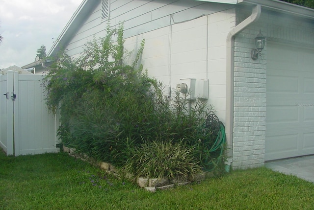 view of property exterior featuring a garage and a yard