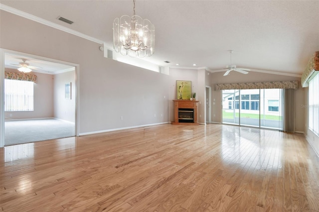 unfurnished living room featuring ceiling fan with notable chandelier, light hardwood / wood-style floors, vaulted ceiling, and ornamental molding