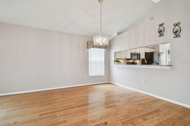 unfurnished living room with lofted ceiling, light wood-type flooring, sink, and an inviting chandelier