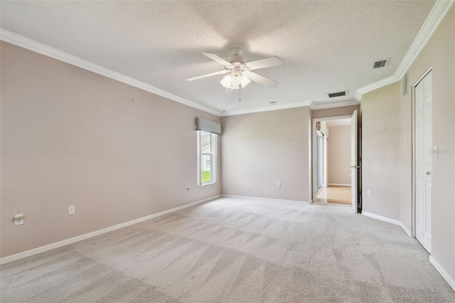 carpeted spare room featuring ceiling fan, a textured ceiling, and ornamental molding