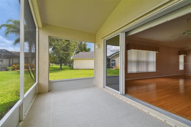 unfurnished sunroom with ceiling fan, a healthy amount of sunlight, and vaulted ceiling