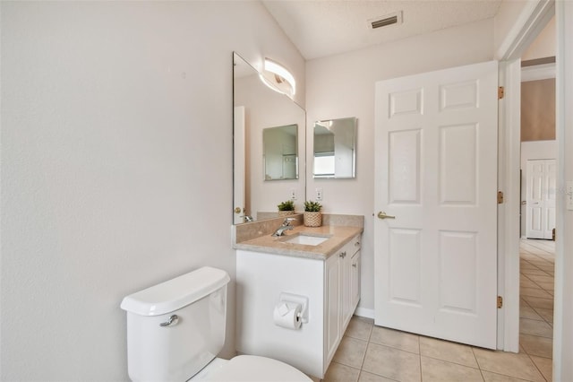 bathroom with tile patterned flooring, vanity, and toilet