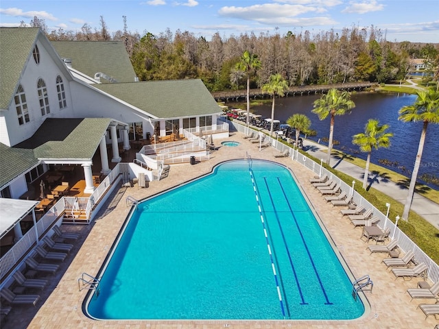 view of pool featuring a water view and a patio