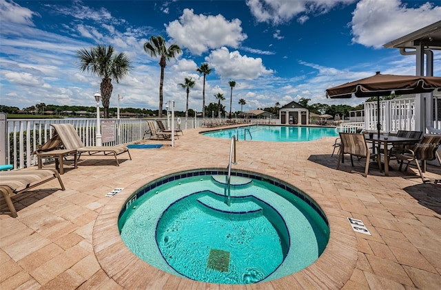 view of pool featuring a community hot tub and a patio