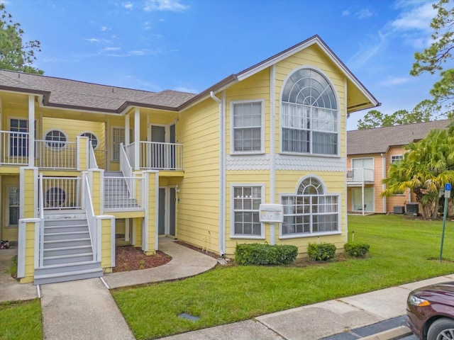 view of property featuring stairs and central AC unit