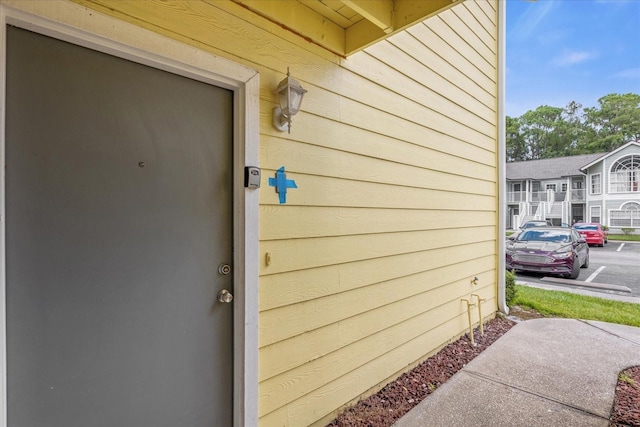 view of exterior entry featuring a residential view and uncovered parking