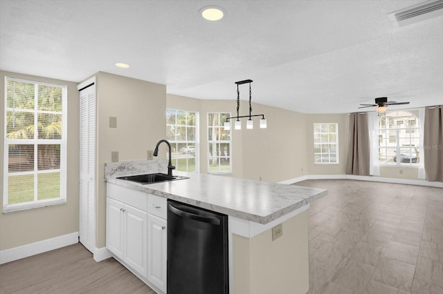 kitchen with dishwashing machine, light countertops, visible vents, and a sink