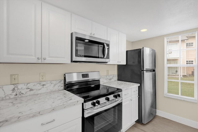 kitchen with baseboards, light countertops, recessed lighting, appliances with stainless steel finishes, and white cabinetry