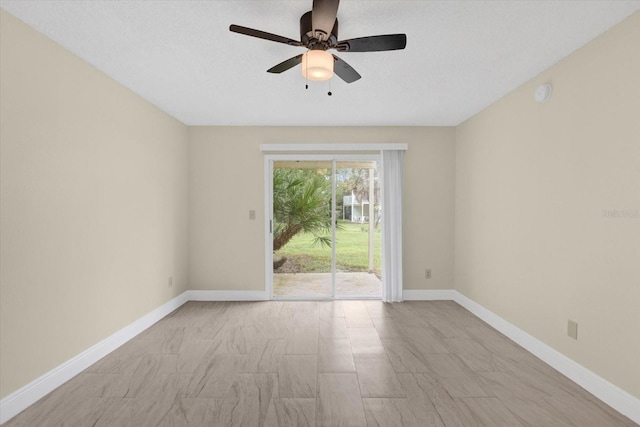 unfurnished room featuring ceiling fan and baseboards