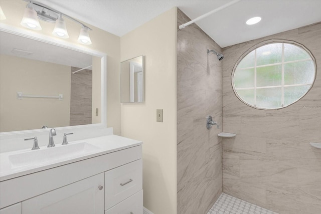 bathroom featuring a tile shower and vanity