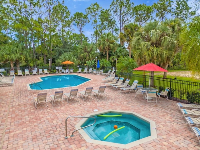 view of pool featuring a patio area, a community hot tub, and fence