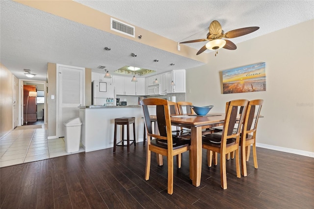 dining space featuring ceiling fan, hardwood / wood-style flooring, and a textured ceiling