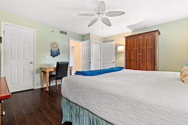 bedroom with ceiling fan, a textured ceiling, and dark hardwood / wood-style flooring