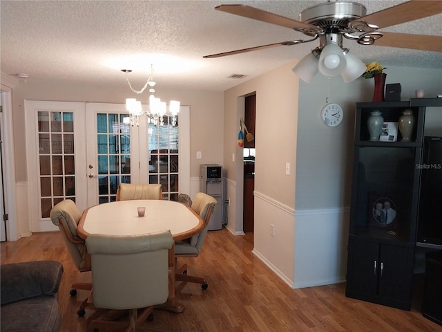 dining room with french doors, hardwood / wood-style flooring, a textured ceiling, and ceiling fan