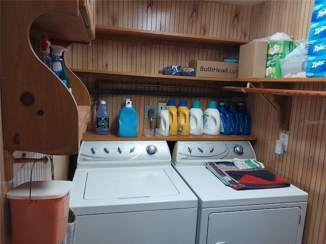 laundry area with wooden walls and independent washer and dryer