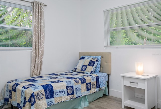 bedroom with light hardwood / wood-style floors and multiple windows