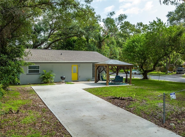 view of front of home with a gazebo, a patio, and a front lawn