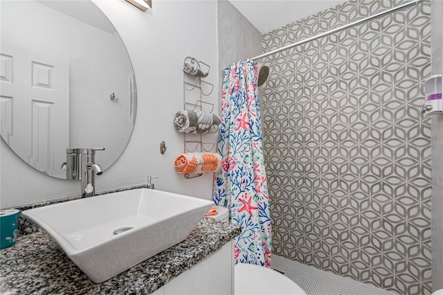 bathroom with curtained shower, vanity, and toilet