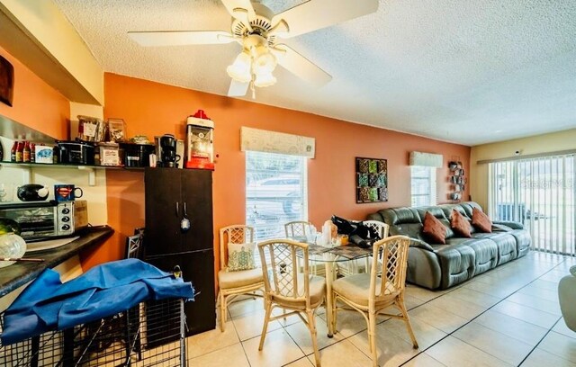 interior space featuring ceiling fan, plenty of natural light, light tile patterned flooring, and a textured ceiling