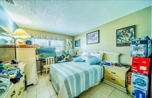 bedroom with a textured ceiling and light tile patterned floors