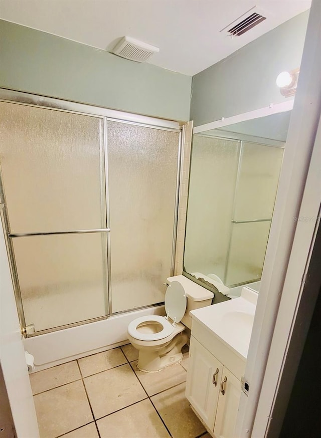 full bathroom with vanity, toilet, tile patterned floors, and bath / shower combo with glass door