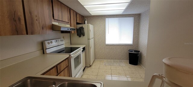 kitchen featuring tile walls, light tile patterned floors, and electric stove