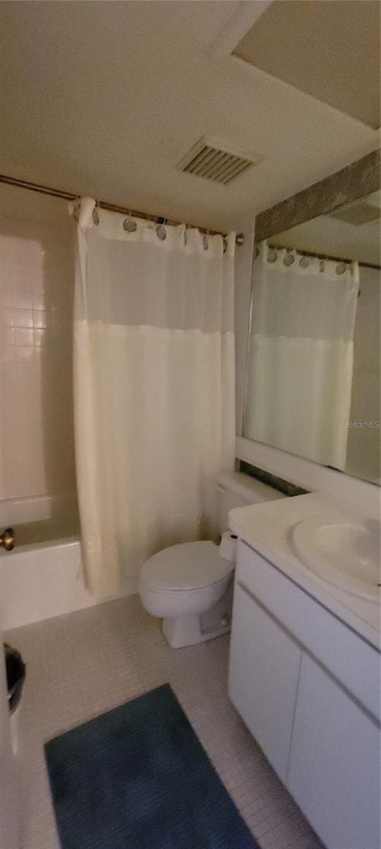 full bathroom featuring shower / bathtub combination with curtain, tile patterned flooring, toilet, and vanity