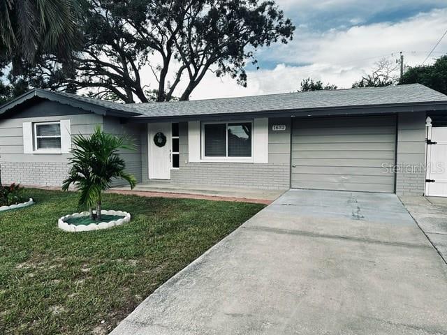 single story home featuring a front yard and a garage