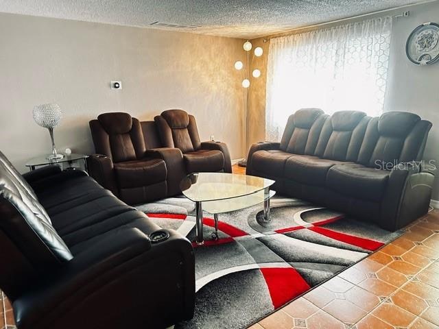 tiled living room with a textured ceiling