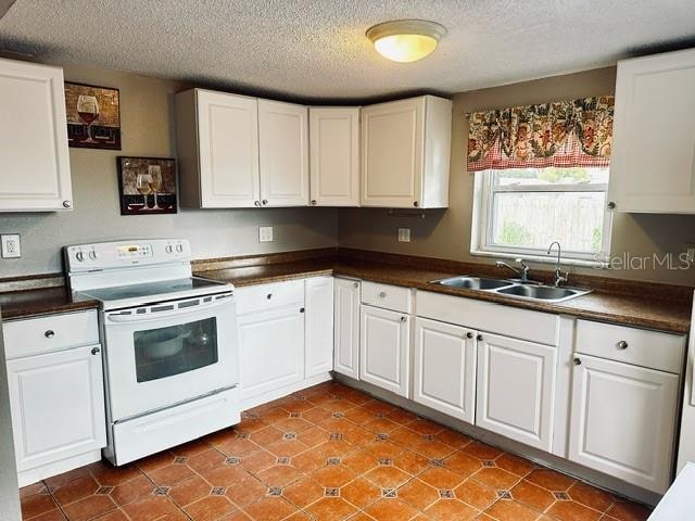 kitchen featuring white cabinets, a textured ceiling, white electric range oven, and sink