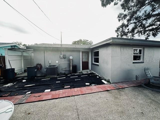 view of front of property with a patio and central AC