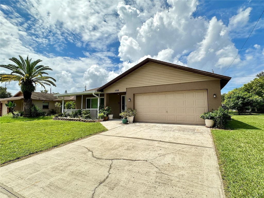 single story home featuring a front lawn, a porch, and a garage