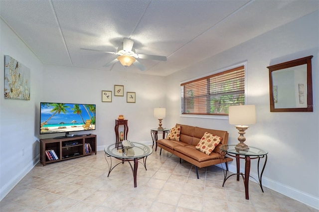 living room with a textured ceiling, ceiling fan, and light tile patterned floors