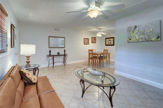 living room with a textured ceiling and ceiling fan