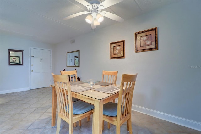 dining room featuring light tile patterned flooring, a ceiling fan, and baseboards