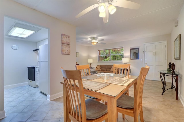 dining space featuring light tile patterned floors, baseboards, and a ceiling fan